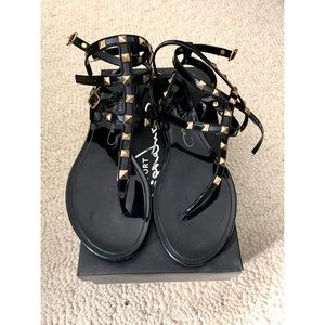 Black gladiator sandals with gold hardware